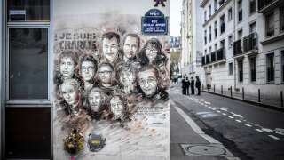 (FILES) In this file photo taken on January 7, 2019 policemen stand in background of a painting by French street artist and painter Christian Guemy, known as C215, in tribute to members of Charlie Hebdo newspaper who were killed by jihadist gunmen in January 2015, outside Charlie Hebdo's former office ahead of a ceremony marking the fourth anniversary of the jihadist attack of the satirical magazine that killed 12 people in Paris. - Two of the 11 sentenced over the 2015 Charlie Hebdo attacks, Ali Riza Polat and Amar Ramdani, are to appear in an appeal trial from September 12, 2022 in Paris for their alleged role in these attacks. (Photo by STEPHANE DE SAKUTIN / AFP) / RESTRICTED TO EDITORIAL USE - MANDATORY MENTION OF THE ARTIST UPON PUBLICATION - TO ILLUSTRATE THE EVENT AS SPECIFIED IN THE CAPTION