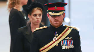 Britain's Prince Harry (R), Duke of Sussex, and Britain's Princess Beatrice of York (L), arrive to mount a vigil around the coffin of Queen Elizabeth II, draped in the Royal Standard with the Imperial State Crown and the Sovereign's orb and sceptre, lying in state on the catafalque in Westminster Hall, at the Palace of Westminster in London on September 16, 2022, ahead of her funeral on Monday. - Queen Elizabeth II will lie in state in Westminster Hall inside the Palace of Westminster, until 0530 GMT on September 19, a few hours before her funeral, with huge queues expected to file past her coffin to pay their respects. (Photo by Ian Vogler / POOL / AFP)