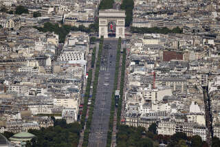 An aerial view shows the Arc de Trimphe during the annual Bastille Day military parade on the Champs-Elysees avenue in Paris on July 14, 2017. - The parade on Paris's Champs-Elysees will commemorate the centenary of the US entering WWI and will feature horses, helicopters, planes and troops. (Photo by JEAN-SEBASTIEN EVRARD / AFP)