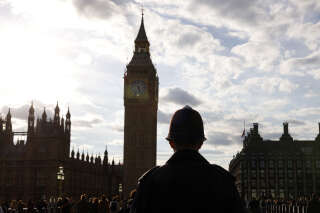 A police officer patrols on Westminster Bridge with the Elizabeth Tower behind, as people queue nearby to pay their respects to the late Queen Elizabeth II, lying in state at the Palace of Westminster, in London on September 18, 2022. - Britain was gearing up Sunday for the momentous state funeral of Queen Elizabeth II as King Charles III prepared to host world leaders and as mourners queued for the final 24 hours left to view her coffin, lying in state in Westminster Hall at the Palace of Westminster. (Photo by Odd ANDERSEN / AFP)