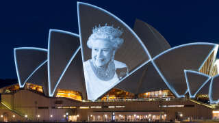 This picture taken on September 9, 2022 shows an image of Britain's Queen Elizabeth II displayed on the Opera House in Sydney. - Queen Elizabeth II, the longest-serving monarch in British history and an icon instantly recognisable to billions of people around the world, died at her Scottish Highland retreat on September 8 at the age of 96. (Photo by Robert WALLACE / AFP)