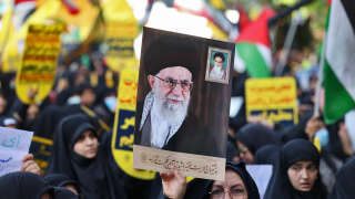 Iranians hold anti US and Israeli signs and a portrait of Iran's Supreme Leader Ayatollah Ali Khamenei during a protest in support of Palestinians following the latest round of fighting between Israel and Palestinian militants, in Tehran, on August 9, 2022. (Photo by ATTA KENARE / AFP)