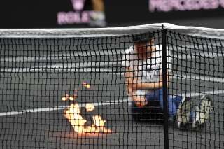 A protester invades the court, appearing to set his arm alight during the singles game between Greece's Stefanos Tsitsipas of Team Europe and Argentina's Diego Schwartzman of Team World at the 2022 Laver Cup at the O2 Arena in London on September 23, 2022. (Photo by Glyn KIRK / AFP) / RESTRICTED TO EDITORIAL USE