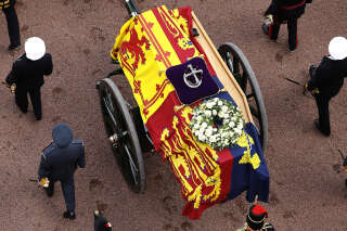 LONDON, ENGLAND - SEPTEMBER 14: Queen Elizabeth II's flag-draped coffin is taken in procession on a Gun Carriage of The King's Troop Royal Horse Artillery from Buckingham Palace to Westminster Hall on September 14, 2022 in London, England. The queen will lay in state until the early morning of her funeral. Queen Elizabeth II died at Balmoral Castle in Scotland on September 8, 2022, and is succeeded by her eldest son, King Charles III.  (Photo by Chip Somodevilla/Getty Images)