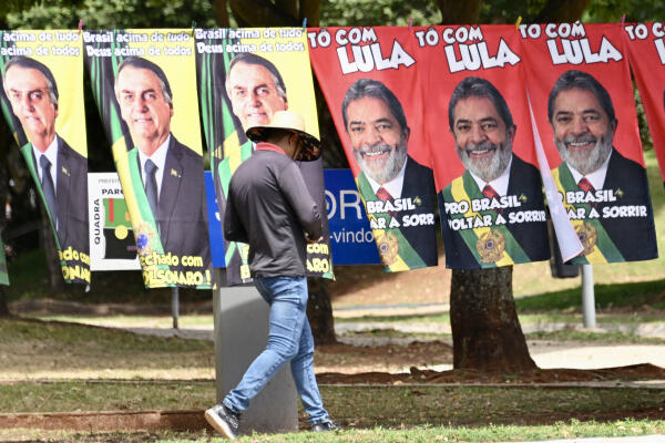 Towels with the images of presidential candidates Jair Bolsonaro and Luiz Inacio Lula da Silva are seen for sale at a street in Brasilia, on September 27, 2022. - Brazil entered the final stretch of the presidential campaign, a high voltage electoral duel between archrivals Jair Bolsonaro and Luiz Inácio Lula da Silva that, according to polls, could be defined already in the first round on October 2 in favor of the former president. (Photo by EVARISTO SA / AFP)