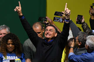 Brazilian President and re-election candidate Jair Bolsonaro greets supporters during a rally in Santos some 60 km from Sao Paulo Brazil on September 27 2022. - Brazil entered the final stretch of the presidential campaign, a high voltage electoral duel between archrivals Jair Bolsonaro and Luiz Inácio Lula da Silva that, according to polls, could be defined already in the first round on October 2 in favor of the former president. (Photo by NELSON ALMEIDA / AFP)