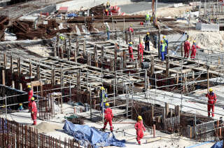 Au Qatar, comme ici sur le chantier du stade Al Bayt, à Doha, des centaines de milliers de travailleurs migrants sont employés. Ils viennent notamment du Pakistan, d’Inde, du Sri Lanka, du Bangladesh et du Népal (photo prise en janvier 2017).