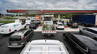 This photograph taken on October 5, 2022, shows drivers lining up as they wait at a Total Energies gas station in Genech, northern France. - More than one out of ten gas stations in France is deprived of all or part of its fuel, especially TotalEnergies, victim of the success of a discount at the pump as well as a strike in its refineries and fuel depots. (Photo by Sameer Al-DOUMY / AFP)