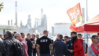 FO Trade unionists and striking employees gather outside the TotalEnergiesrefinery site, in Donges, western France, on October 12, 2022. - France's Prime Minister announced on October 11, 2022 the requisition of staff to unlock the fuel depots of the group Esso-Exxonmobil, where a wage agreement was reached on October 10, 2022 by two trade unions, which have a majority at the group but not at its refineries. (Photo by DAMIEN MEYER / AFP)