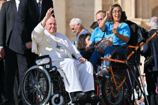Pope Francis waves from his wheelchair as he goes to bless disabled people at the end of the weekly general audience on October 19, 2022 at St. Peter's square in The Vatican. (Photo by Alberto PIZZOLI / AFP)
