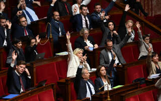 French far-right party Rassemblement National (RN) leader and Member of Parliament Marine Le Pen (C) rises her hand during the reading of the Social Security (Securite Sociale) financing bill at the National Assembly in Paris on October 20, 2022. - A 49.3 triggered on the state budget, a second approaching on that of the Secu: as in 