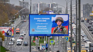 Une photographie prise le 24 octobre 2022 montre une affiche d’un soldat russe avec un slogan indiquant « Gloire aux héros de la Russie », décorant une rue de Moscou.