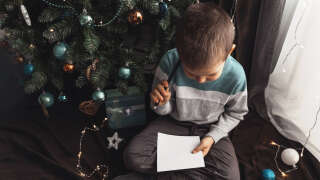 Little boy write Christmas wishes to Santa