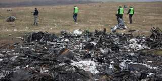 (FILES) In this file photo taken on November 11, 2014, Dutch investigators accompanied by pro-Russian armed rebels arrive near parts of the Malaysia Airlines Flight MH17 at the crash site near the Grabove village in eastern Ukraine, hoping to recover debris from the Malaysia Airlines plane which crashed in July, killing 298 people, in remote rebel-held territory east of Donetsk. - A Dutch court gives its verdict on November 17, 2022 in the trial of four men over the downing of Malaysia Airlines flight MH17 above Ukraine in 2014, as tensions soar over Russia's invasion eight years later. All 298 passengers and crew were killed when the Boeing 777 flying from Amsterdam to Kuala Lumpur was hit over separatist-held eastern Ukraine by what investigators say was a missile supplied by Moscow. (Photo by Menahem KAHANA / AFP)