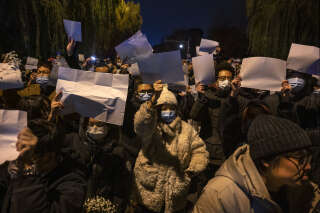 BEIJING, CHINA -NOVEMBER 27: Protesters hold up a white piece of paper against censorship during a protest against Chinas strict zero COVID measures on November 27, 2022 in Beijing, China. Protesters took to the streets in multiple Chinese cities after a deadly apartment fire in Xinjiang province sparked a national outcry as many blamed COVID restrictions for the deaths. (Photo by Kevin Frayer/Getty Images)