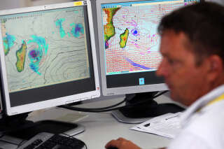 Un homme regarde une carte météo, le 2 janvier 2013 au siège local de Météo France à Saint-Denis de la Réunion, une île française située dans l’océan Indien, alors que la tempête tropicale Dumile devrait frapper l’île sous forme de cyclone tropical dans la journée. AFP PHOTO RICHARD BOUHET (Photo de RICHARD BOUHET / AFP)