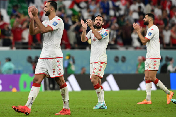 Tunisia's defender #12 Ali Maaloul and teammates celebrate at the end of the Qatar 2022 World Cup Group D football match between Tunisia and France at the Education City Stadium in Al-Rayyan, west of Doha on November 30, 2022. (Photo by Miguel MEDINA / AFP)