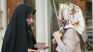 Dans cette photo d’archive prise le 23 juillet 2007, une policière iranienne (R) parle à une femme au sujet de ses vêtements lors d’une opération de répression visant à faire respecter le code vestimentaire islamique dans la capitale Téhéran. - L’Iran a supprimé sa police des mœurs après plus de deux mois de protestations déclenchées par l’arrestation de Mahsa Amini pour avoir prétendument violé le code vestimentaire féminin strict du pays, ont déclaré les médias locaux le 4 décembre 2022. (Photo de Behrouz MEHRI / AFP)