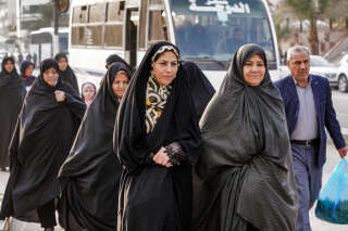 Iranians disembark walk towards a market area for shopping during their visit to Iraq's central holy shrine city of Najaf on December 4, 2022. - Iran has scrapped its morality police after more than two months of protests triggered by the death of Mahsa Amini following her arrest for allegedly violating the country's strict female dress code, local media said on December 4. Women-led protests, labelled 