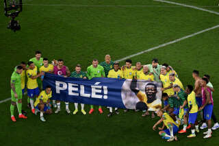 Les Brésiliens affichent une banderole de soutien à Pelé sur le terrain après leur victoire