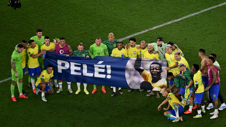 Brazil's players hold a banner dedicated to banner Brazilian football legend Pele at the end of the Qatar 2022 World Cup round of 16 football match between Brazil and South Korea at Stadium 974 in Doha on December 5, 2022. (Photo by Antonin THUILLIER / AFP)