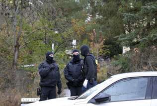 German special police forces stand guard and patrol in a neighbourhood in south western Berlin on December 7, 2022 as part of nationwide early morning raids against members of a far-right 