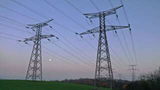 A photograph shows an aerial view of electric pylons and moon in the countryside of Saint-Laurent-de-Terregatte, western France on December 6, 2022. - France may face 