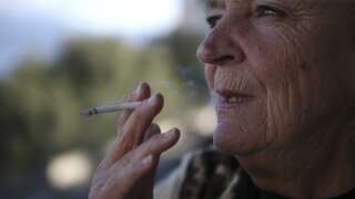 A woman smokes a cigarette in Ajaccio on December 16, 2021 on the French Mediterranean island of Corsica. - Corsica wants to be at the forefront of lung cancer screening, the leading cause of cancer deaths in France and particularly active on the island, thanks to the launch of a study to detect 