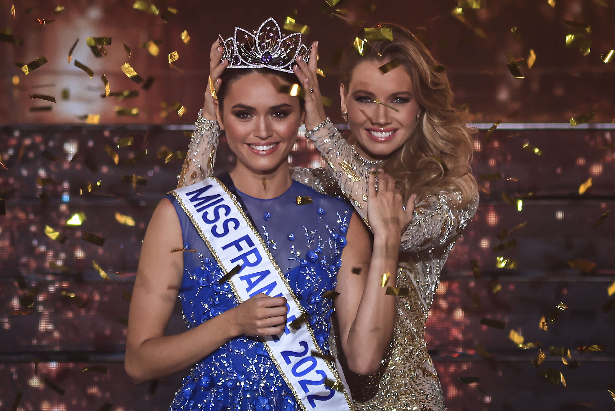 Miss Ile-de-France Diane Leyre is crowned by Miss France 2021 Amandine Petit at the end of the the Miss France 2022 beauty contest in Caen, on December 11, 2021. (Photo by Sameer Al-DOUMY / AFP)