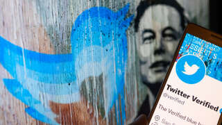 Twitter Verified icon seen on mobile screen with Elon Musk in the background illustration, in Brussels, Belgium, on December 11, 2022 (Photo illustration by Jonathan Raa/NurPhoto via Getty Images)