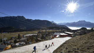 Des touristes skient sur une fine couche de neige en direction de la station de Leysin, dans les Alpes suisses, le 28 décembre 2015.