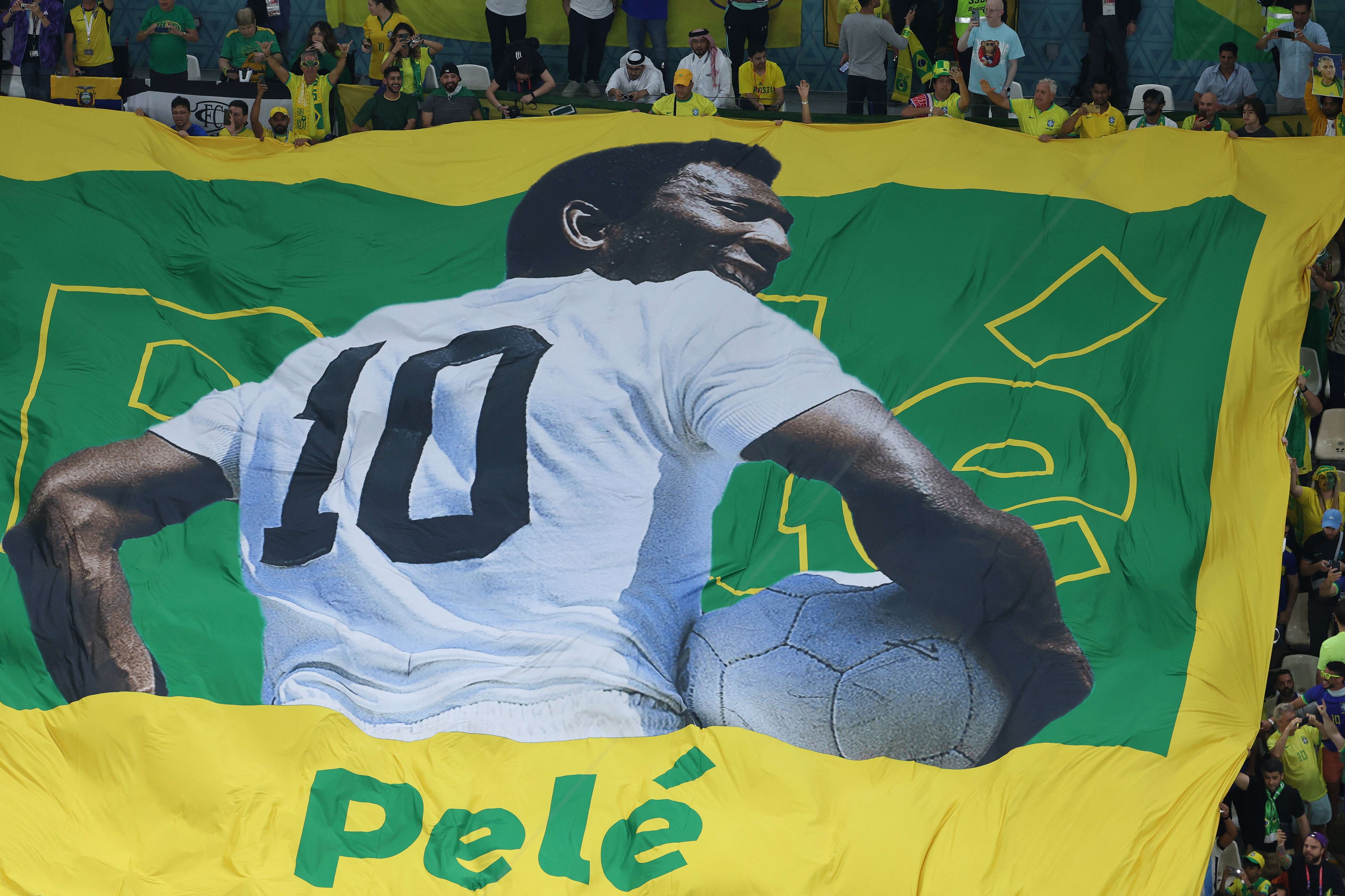 A large flag of Brazil legend Pele is unveiled in the crowd ahead of the Qatar 2022 World Cup Group G football match between Cameroon and Brazil at the Lusail Stadium in Lusail, north of Doha on December 2, 2022. (Photo by Giuseppe CACACE / AFP)