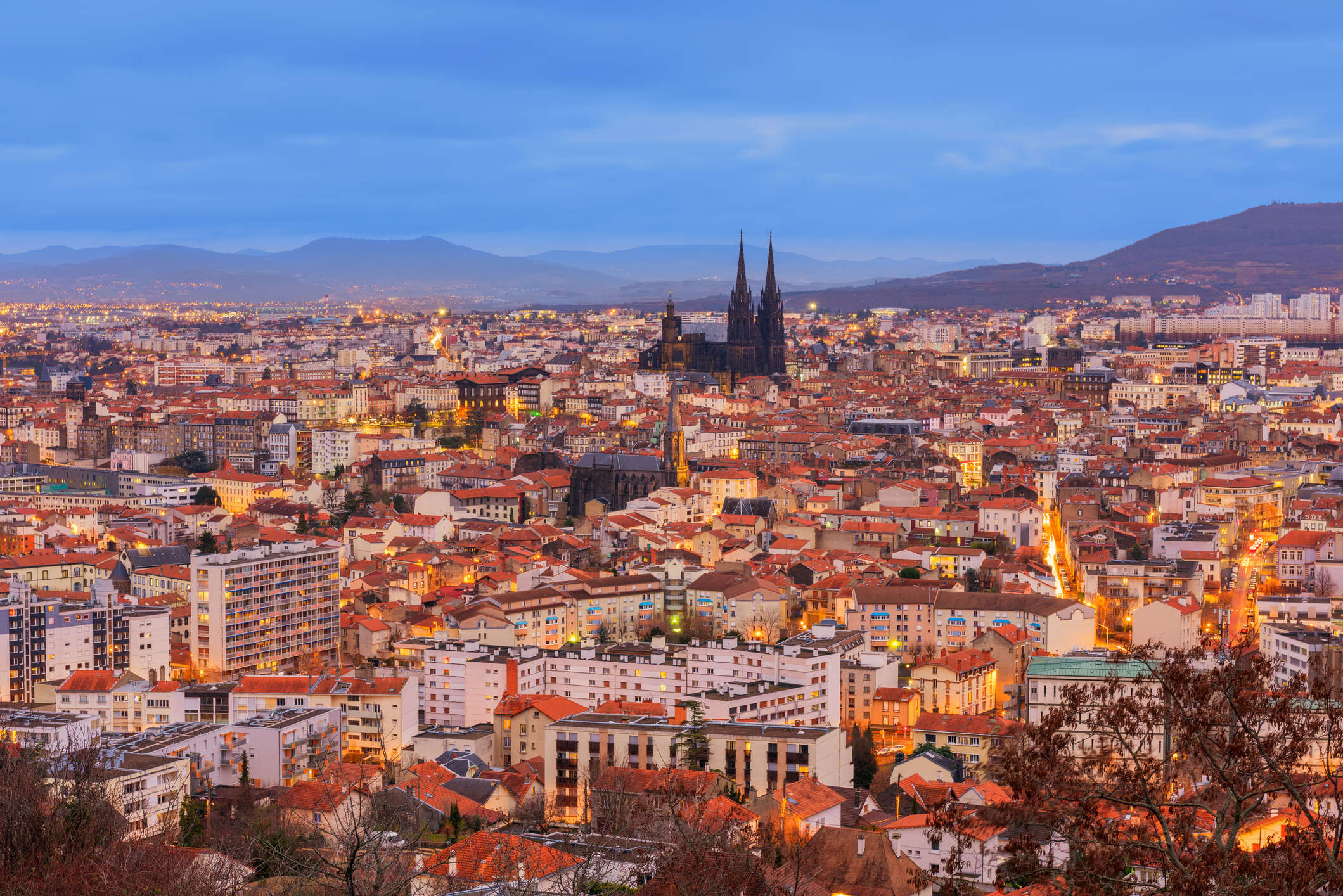 Skyline of Clermont-Ferrand, Auvergne, France at Dusk. Main focal point is the 13th Century Cathedral of Our Lady of the Assumption of Clermont-Ferrand, built entirely in black lava stone. Its twin spires are 96.1 metres tall.