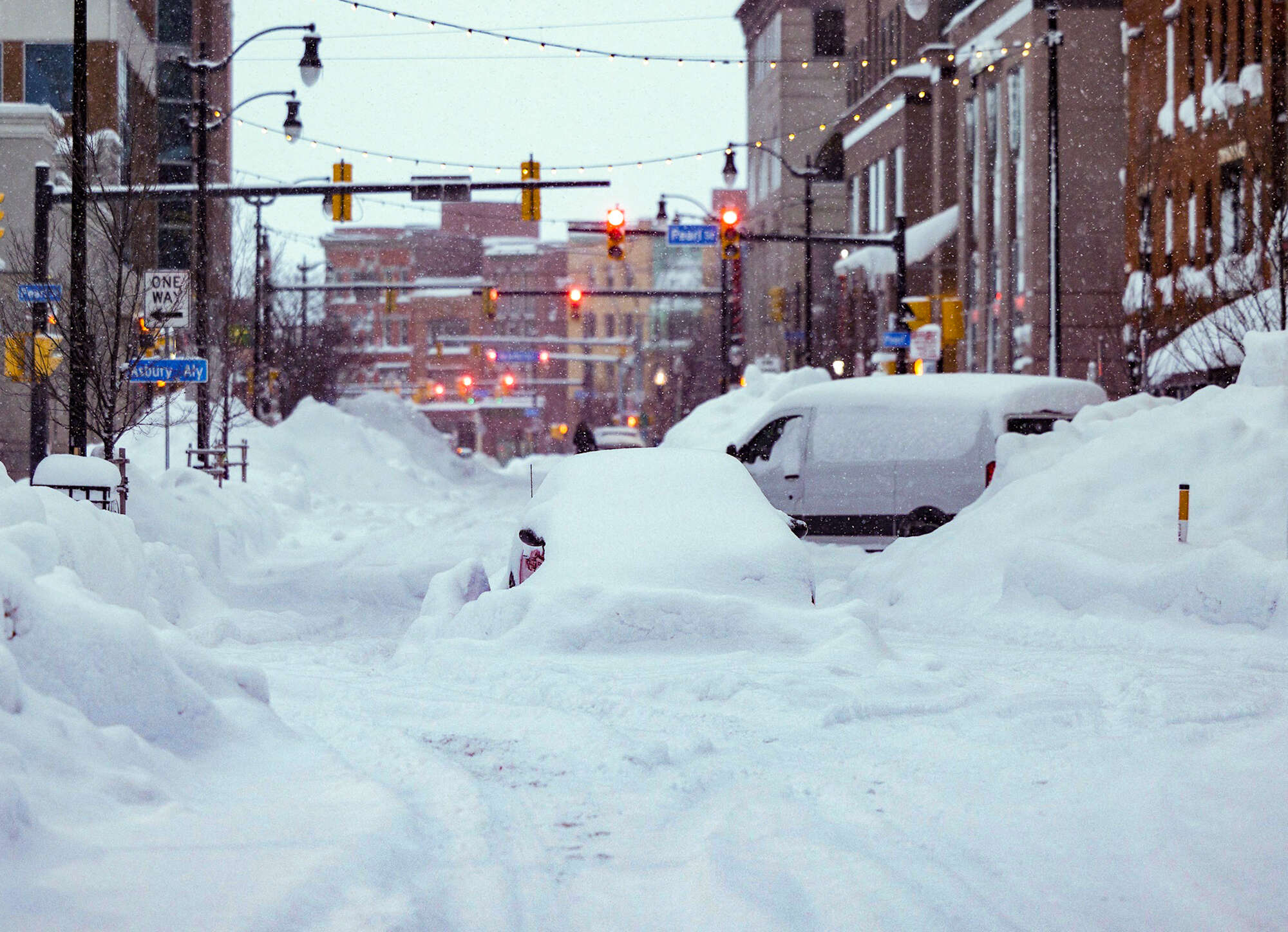 In this handout photo from the Office of Governor Kathy Hochul vehicles are seen trapped under heavy snow in the streets of downtown Buffalo, New York, on December 26, 2022. - US emergency crews counted the grim costs of a colossal winter storm that brought Christmas chaos to millions, especially in hard-hit western New York, where the death toll reached 25 Monday in what authorities described as a 