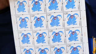 A man shows Year of the Rabbit stamps at a post office in Lianyungang, in China's easern Jiangsu province, on January 5, 2023, ahead of the Lunar New Year. (Photo by AFP) / China OUT