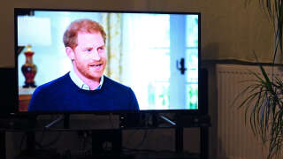 A member of the public poses in his front room in Manchester, north-west England, watching a television interview broadcast on ITV, being given by Britain's Prince Harry, Duke of Sussex on January 8, 2023, ahead of the publication of his book, 'Spare'. - Prince Harry discusses his memoirs in a television interview Sunday after the book's explosive revelations about royal rifts, sex and drugs cast doubt on his future in the British royal family. The 38-year-old prince's ghost-written book 