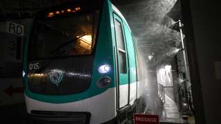 This picture taken on October 20, 2022 shows a metro train passing through a washing station on its way to a Regie Autonome des Transports Parisiens (RATP) storage area in Paris. (Photo by Christophe ARCHAMBAULT / AFP)