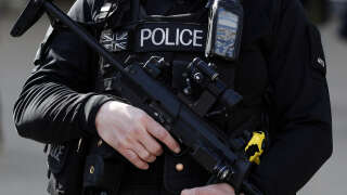 An armed British police officer holds his automatic weapon as he stands on duty in central London on March 22, 2016. - Britain boosted security at its international transport hubs following the deadly attacks in Brussels today, as Prime Minister David Cameron urged Europe to stand together against the terror threat. A string of explosions rocked Brussels airport and a city metro station on Tuesday, killing at least 21 people, according to firefighters, as Belgium raised its terror threat to the maximum level. (Photo by ADRIAN DENNIS / AFP)