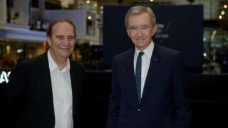 French luxury group LVMH Chairman and Chief Executive Officer Bernard Arnault (R) poses with Iliad Group founder and vice-president Xavier Niel (L) as they attend the launch of LVMH