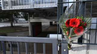 This photograph taken on January 13, 2023, shows a bouquet of flowers attached at the main entrance of the Louis Armand secondary school in Golbey, eastern France, where was schooled Lucas, a 13-year-old boy who committed suicide. - The suicide of a 13-year-old French boy who was subjected to homophobic bullying at school has prompted expressions of shock in the country and warnings that homophobia kills. Prosecutors have opened an investigation into harassment of a minor after the boy, Lucas, took his own life last weekend in the Vosges region of eastern France. (Photo by Frederick FLORIN / AFP)