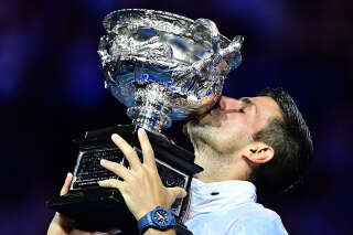 Serbia's Novak Djokovic celebrates with the Norman Brookes Challenge Cup trophy following his victory against Greece's Stefanos Tsitsipas in the men's singles final match on day fourteen of the Australian Open tennis tournament in Melbourne on January 29, 2023. (Photo by MANAN VATSYAYANA / AFP) / -- IMAGE RESTRICTED TO EDITORIAL USE - STRICTLY NO COMMERCIAL USE --