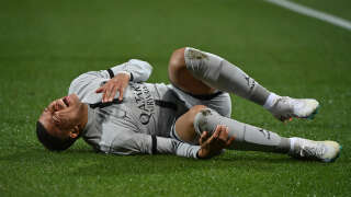 Paris Saint-Germain's French forward Kylian Mbappe lies on the ground after getting injured during the French L1 football match between Montpellier Herault SC and Paris Saint-Germain (PSG) at Stade de la Mosson in Montpellier, southern France on February 1, 2023. (Photo by Sylvain THOMAS / AFP)