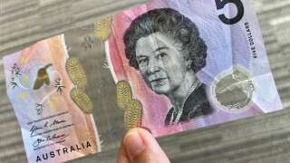 This photo illustration taken in Hong Kong on February 2, 2023 shows the Australian $5 banknote. - Australia's central bank announced on February 2, 2023 it will erase the British monarch from its banknotes, replacing the late Queen Elizabeth II's image on its $5 note with a design honouring Indigenous culture. (Photo by Mladen ANTONOV / AFP)