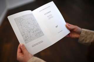 A woman holds a copy of French writer Louis-Ferdinand Celine's novel 'Guerre' (War), two days ahead of its release, at the Gallimard gallery during the exhibition titled 