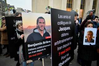 Demonstrators hold portraits of French detainees in Iran Benjamin Briere (L) and Jacques Paris (R) during a protest in support of French nationals detained by Iranian government, at the 