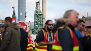 CGT Trade unionists and employees gather at the Total Energy refinery site, in Gonfreville-l'Orcher, near Le Havre, northwestern France, on October 18, 2022. - France is experiencing a day of major disruptions on October 18, 2022, after unions called a nationwide transport strike as they remain in deadlock with the government over walkouts at oil depots that have sparked fuel shortages. The move comes after workers at several refineries and depots operated by energy giant TotalEnergies voted to extend their strike action. (Photo by Lou BENOIST / AFP)