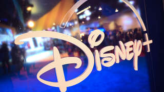 (FILES) In this file photo taken on September 09, 2022 fans are reflected in Disney+ logo during the Walt Disney D23 Expo in Anaheim, California. - Disney's streaming service saw its first ever fall in subscribers last quarter, company data showed on February 8, 2023, as consumers cut back on spending amid higher costs and a souring global economy. Disney CEO Bob Iger on February 8, 2023, announced that the company would lay off 7,000 workers, in the veteran executive's first major decision since returning to lead the company in November. (Photo by Patrick T. FALLON / AFP)