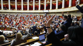 MP raise their hands to vote in a session to discuss on the government's pension reform plan at the National Assembly, French Parliament lower house, in Paris, on February 13, 2023. (Photo by Ludovic MARIN / AFP)