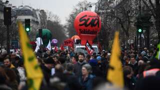 Protesters walk next to a giant balloon of the Sud trade union during a demonstration on the fourth day of nationwide rallies organised since the start of the year, against a deeply unpopular pensions overhaul, near Nation Square in Paris on February 11, 2023. (Photo by Christophe ARCHAMBAULT / AFP)
