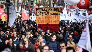 Protestors hold unions' flags and signs during a demonstration on the fifth day of nationwide rallies organised since the start of the year, against a deeply unpopular pensions overhaul, in Paris, on February 16, 2023. (Photo by Emmanuel DUNAND / AFP)